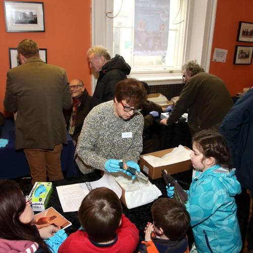 Photograph of a group looking at an object