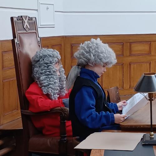 Children playing magistrates in courtroom