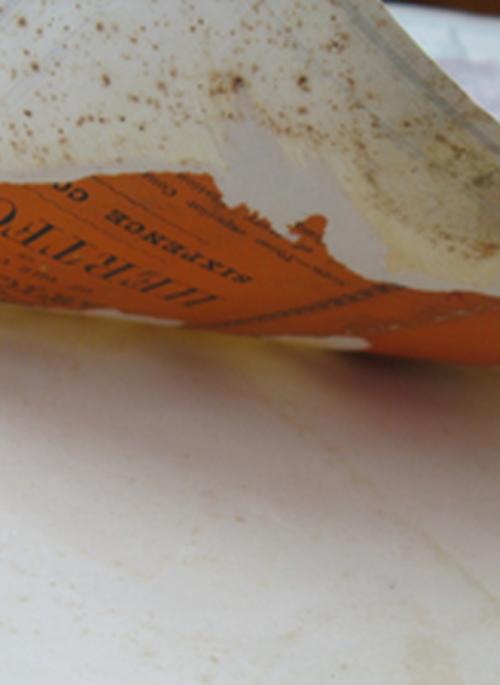 Close-up photograph of a page of an old map being turned by a single finger